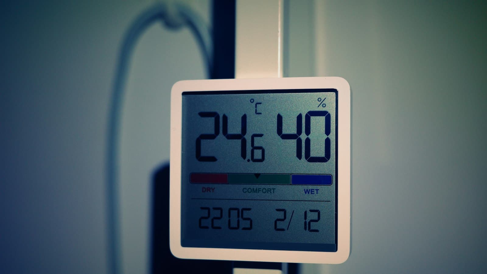 A digital thermometer with a large temperature display hanging on a door