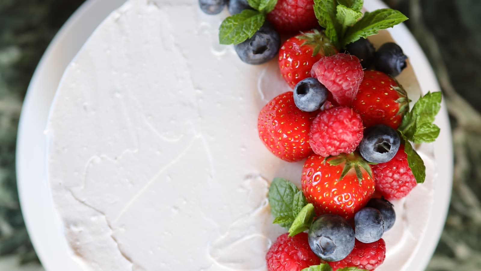 Fresh raspberries, strawberries and blueberries in bowls on a table
