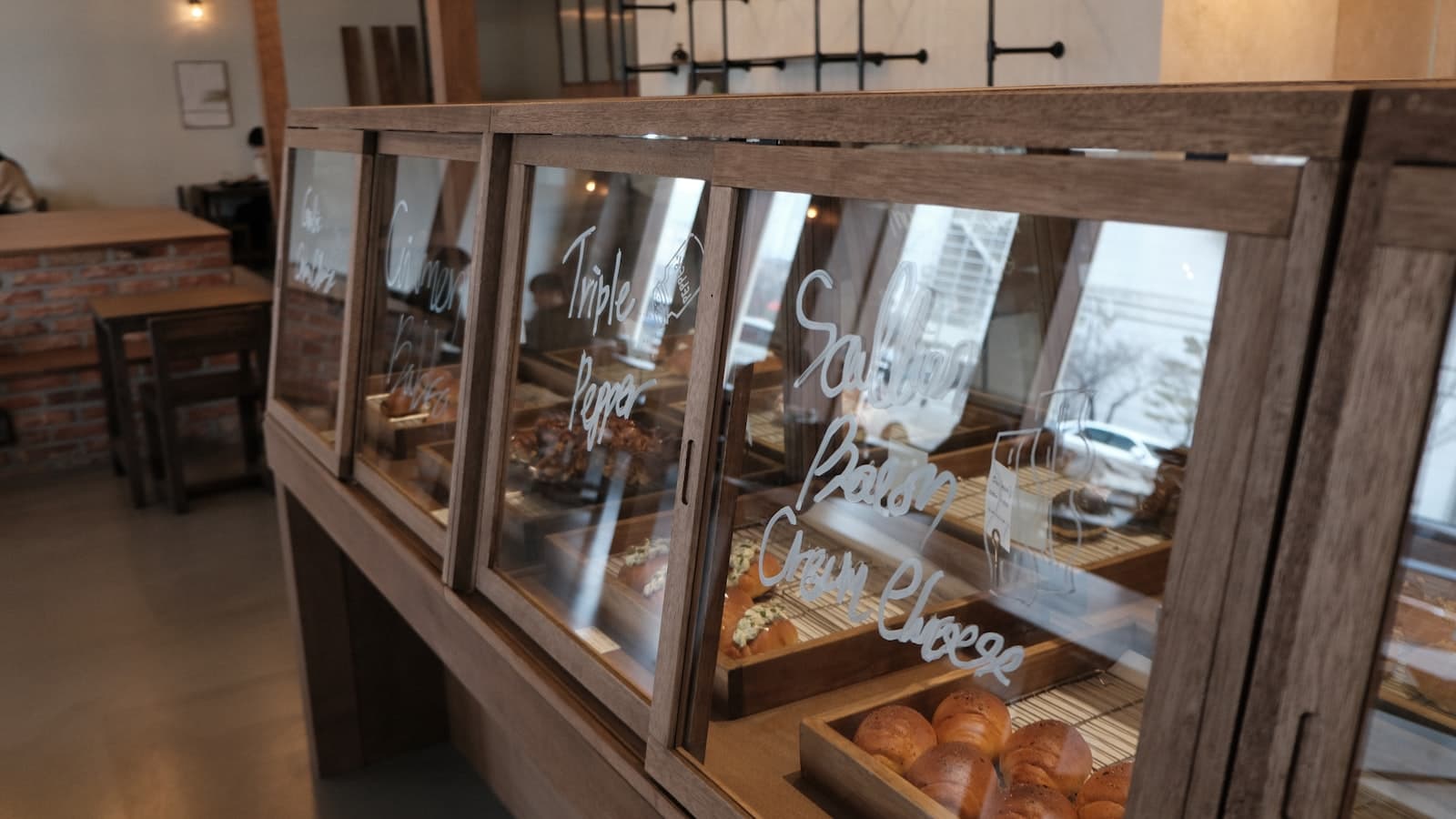 An elegant pastry shop display with eclairs, tarts and desserts on the shelves